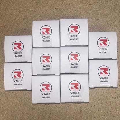 10 boxes of Root Industries AIR Headset are arranged in a pyramid formation on a brown surface.